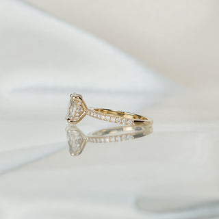 Side view of an oval hidden halo engagement ring, the concealed circle of round brilliants visible beneath the basket.