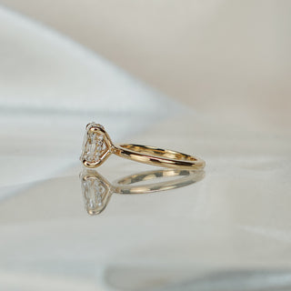 Side view of an oval hidden halo solitaire, the under-stone circle visible above the plain yellow gold shank.