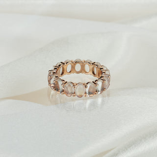Natural Moonstone full eternity ring in 14k rose gold on satin fabric, sixteen oval stones in shared claws around the band.