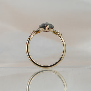 Pear shape salt and pepper Diamond engagement ring standing upright with reflection, baguette accents beneath the center.