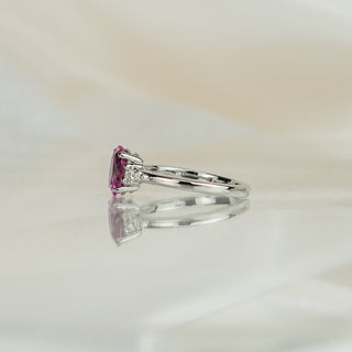 Side view of an oval pink Sapphire three-stone ring, showing the basket and tapering white gold shank.