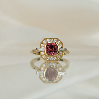 Yellow gold engagement ring with a 1.43 carat cushion cut pink Spinel in a geometric frame of round brilliants and baguettes.