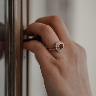 Pink Spinel geometric engagement ring worn on the hand, art deco style frame in yellow gold.