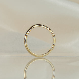 14k yellow gold shadow band standing upright with reflection, plain polished finish and curved silhouette.