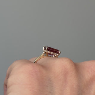 Video of a yellow gold pink Tourmaline hidden halo solitaire worn on the hand, rouge-pink center in motion over concealed Diamonds.