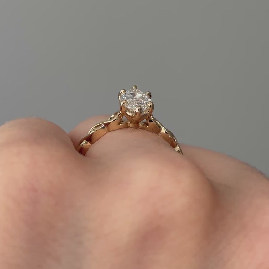 Video of a yellow gold marquise lab grown diamond solitaire worn on the hand, braided shank turning through the light.