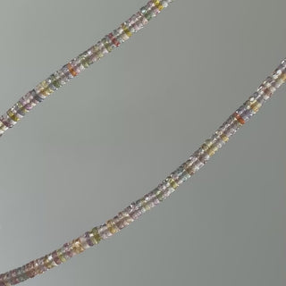 Video of a natural multi-color Sapphire tire bead necklace, strand in motion showing pastel color shifts between beads.
