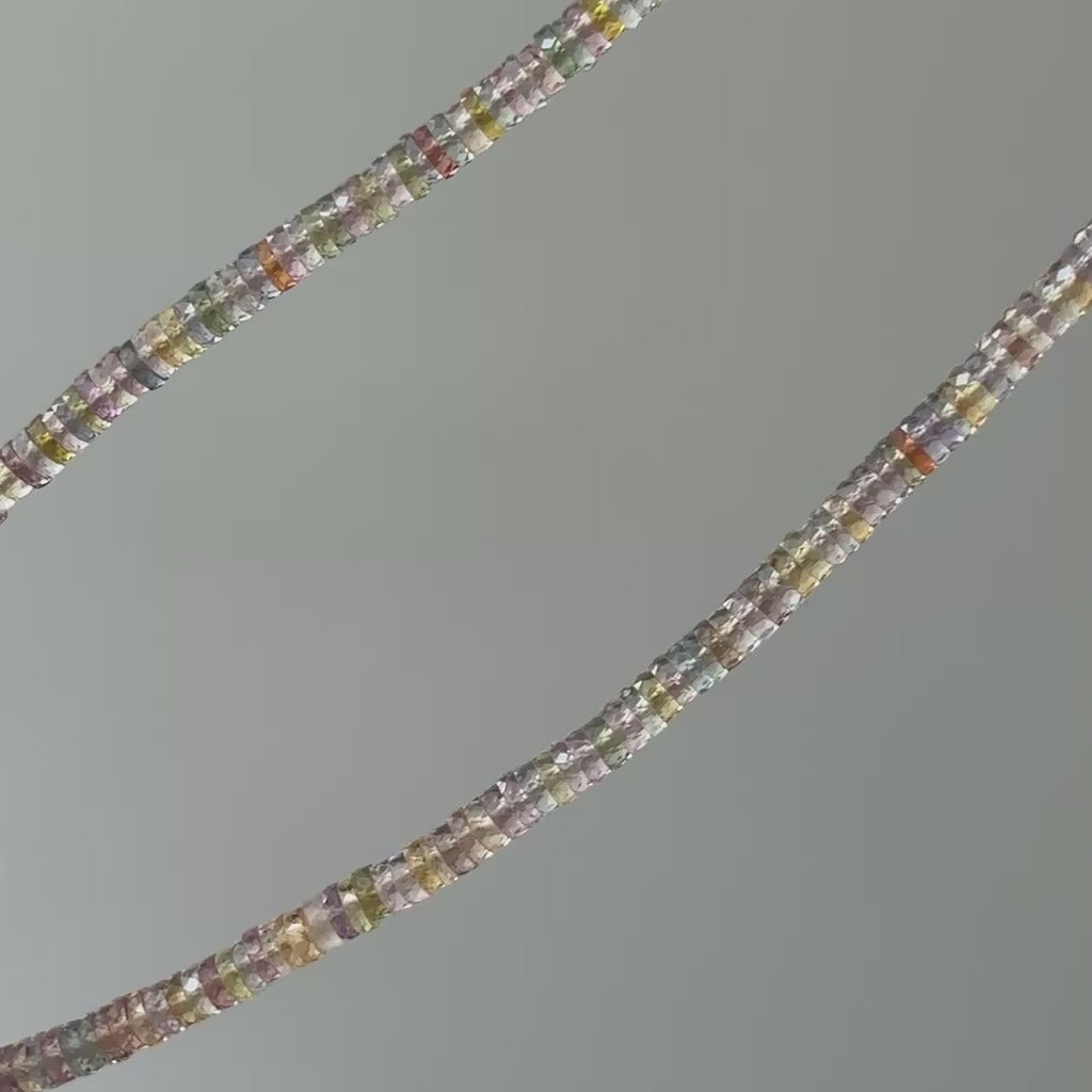 Video of a natural multi-color Sapphire tire bead necklace, strand in motion showing pastel color shifts between beads.