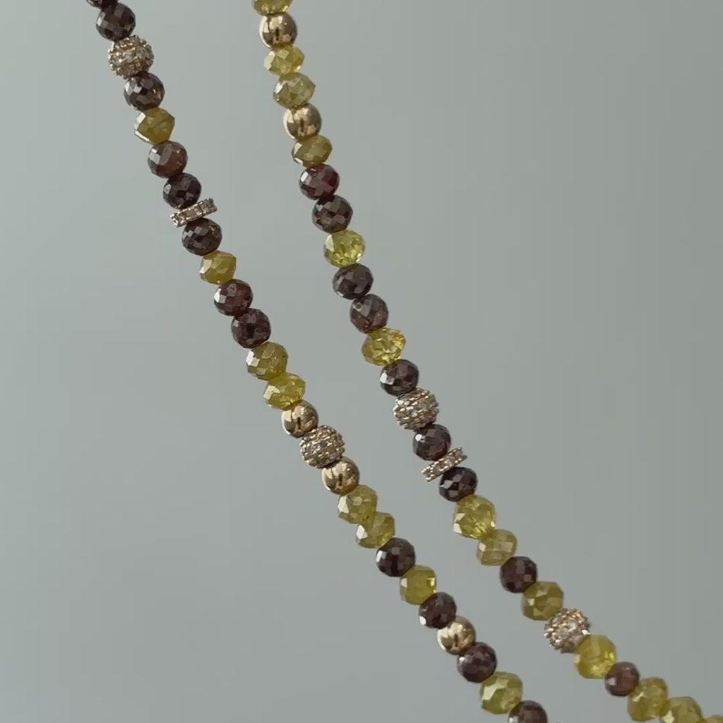 Natural yellow and brown diamond bead necklace, close view of faceted beads and gold accents in motion.