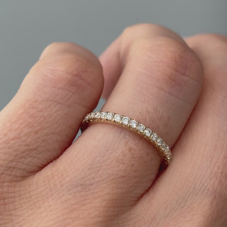 Video of a yellow gold lab grown diamond micro pavé half eternity band worn on the hand, fine stone row in motion.