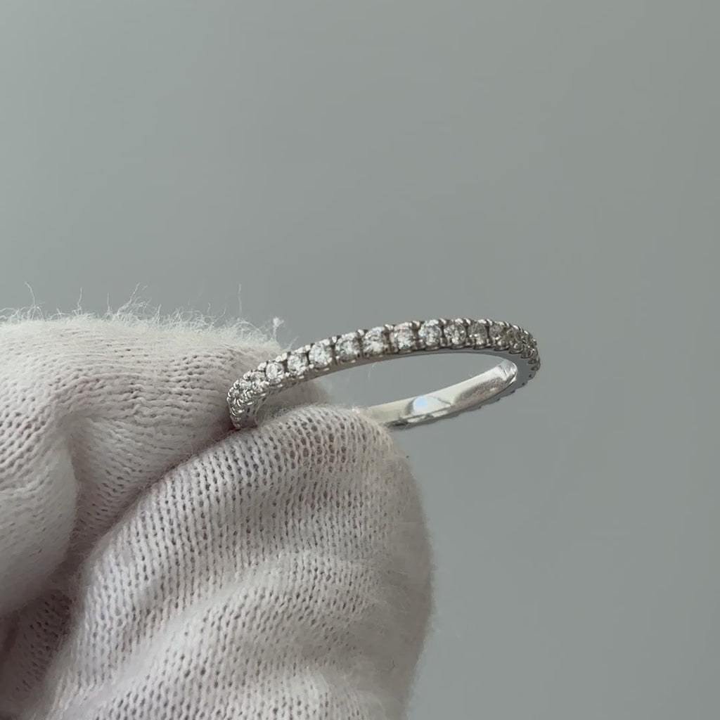 Video of a white gold lab grown diamond micro pavé band on a gloved hand, fine stone line turning through the light.