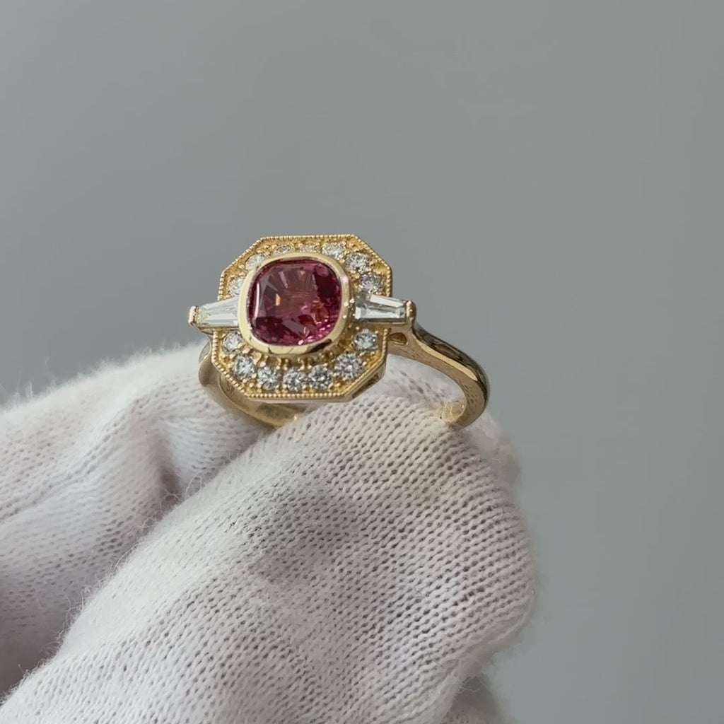 Video of a yellow gold pink Spinel geometric engagement ring on a gloved hand, milgrain frame and pink center turning through the light.