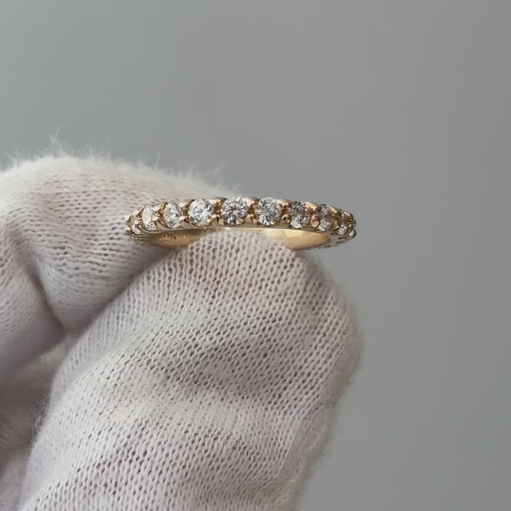 Video of a lab grown diamond half eternity scallop band on a gloved hand, stone row catching light as it turns.