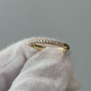 Video of a yellow gold natural Diamond micro pavé band on a gloved hand, fine stone line catching light as it turns.