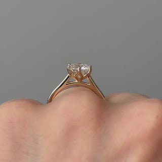 Video of a yellow gold round brilliant lab grown diamond flower head solitaire worn on the hand, elevated crown turning through the light.