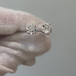 Video of lab grown diamond round brilliant studs held on a gloved hand, stones showing brilliance in motion.