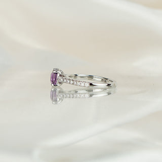 Side view of a purple Sapphire cathedral engagement ring, arched shoulders rising to the four-prong center.