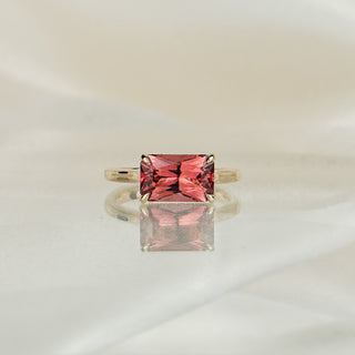 Yellow gold solitaire with a 2.84 carat radiant cut pink Tourmaline set east-west, hidden halo tucked beneath the basket.
