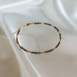 Natural brown Diamond bead bracelet resting open on ivory satin, raw faceted stones catching soft light.