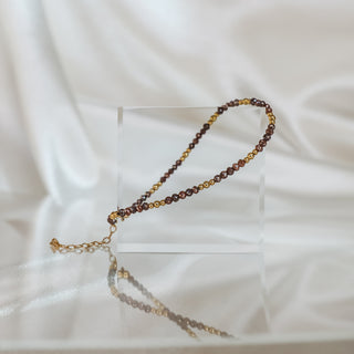 Brown raw faceted Diamond bracelet laid long on an acrylic block, warm stones alternating with 14k gold beads.