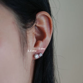 Two sizes of lab grown diamond studs worn on the ear, showing scale difference between carat weights.