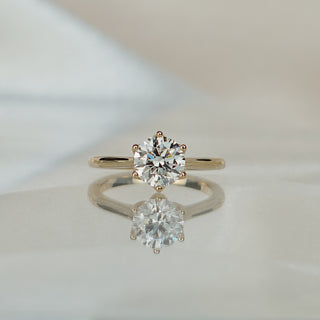Yellow gold solitaire with a 1.54 carat round brilliant lab diamond in a flower head setting, slim 1.9mm band below.
