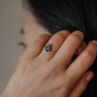 Salt and pepper pear engagement ring worn on the hand, grey rose cut Diamond in yellow gold.
