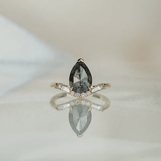 Yellow gold engagement ring with a 2.16 carat pear shape rose cut salt and pepper Diamond above a curved row of accents.