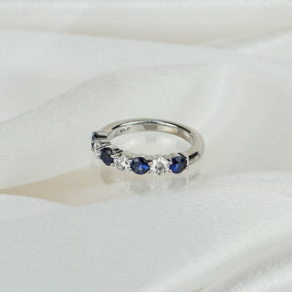 Natural Ceylon blue Sapphire and Diamond wedding band in white gold on satin fabric, four sapphires alternating three round brilliants in shared claws.