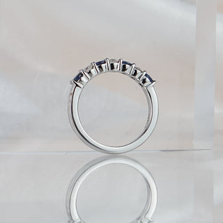 Blue Sapphire and Diamond alternating band standing upright with reflection, shared claws and polished platinum back visible.