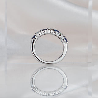 Blue Sapphire and Diamond alternating band standing upright with reflection, shared claws and polished back in frame.