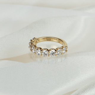 Lab grown diamond half eternity band in yellow gold on satin fabric, nine large round brilliants in scallop shared claws.