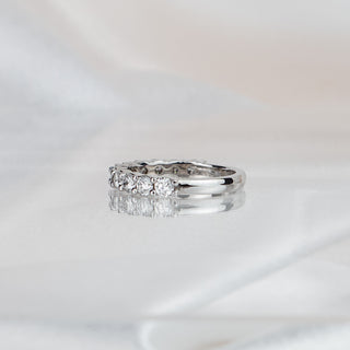 Side view of a lab diamond shared claw band in white gold, stones tapering to a plain polished back.