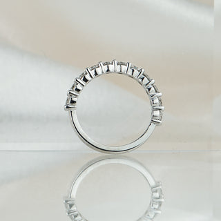 Shared claw half eternity band standing upright with reflection, eleven round brilliants held in open claws.
