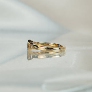 Side view of a teal Sapphire three-stone ring in yellow gold, showing the bezel walls and flat band profile.