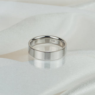 14k white gold flat wedding band with comfort fit interior on white satin fabric, 14K hallmark stamped inside the band.