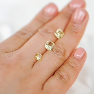 Gold ring with gemstones on a hand against a white background