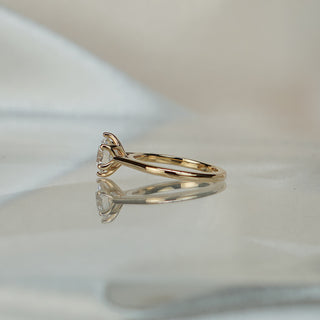 Side view of a round flower head cathedral solitaire, arched shoulders lifting the six-prong crown in yellow gold.