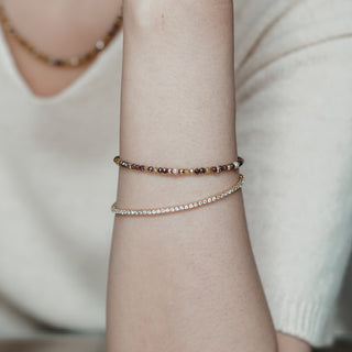 Natural Diamond tennis bracelet worn on the wrist in yellow gold, styled with a cream sweater.